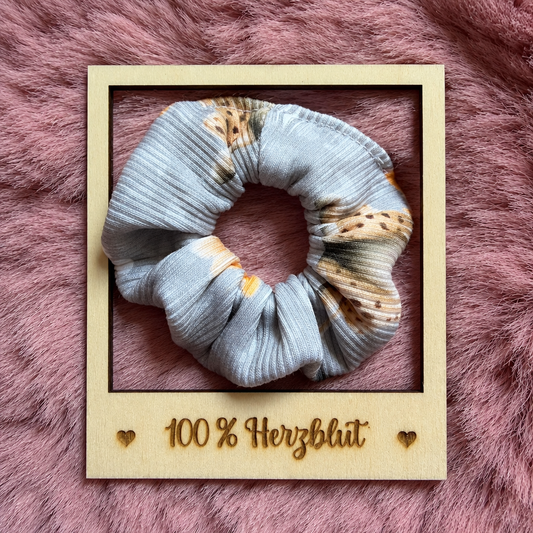 Hellblauer Scrunchie im Holzrahmen im Format 1:1