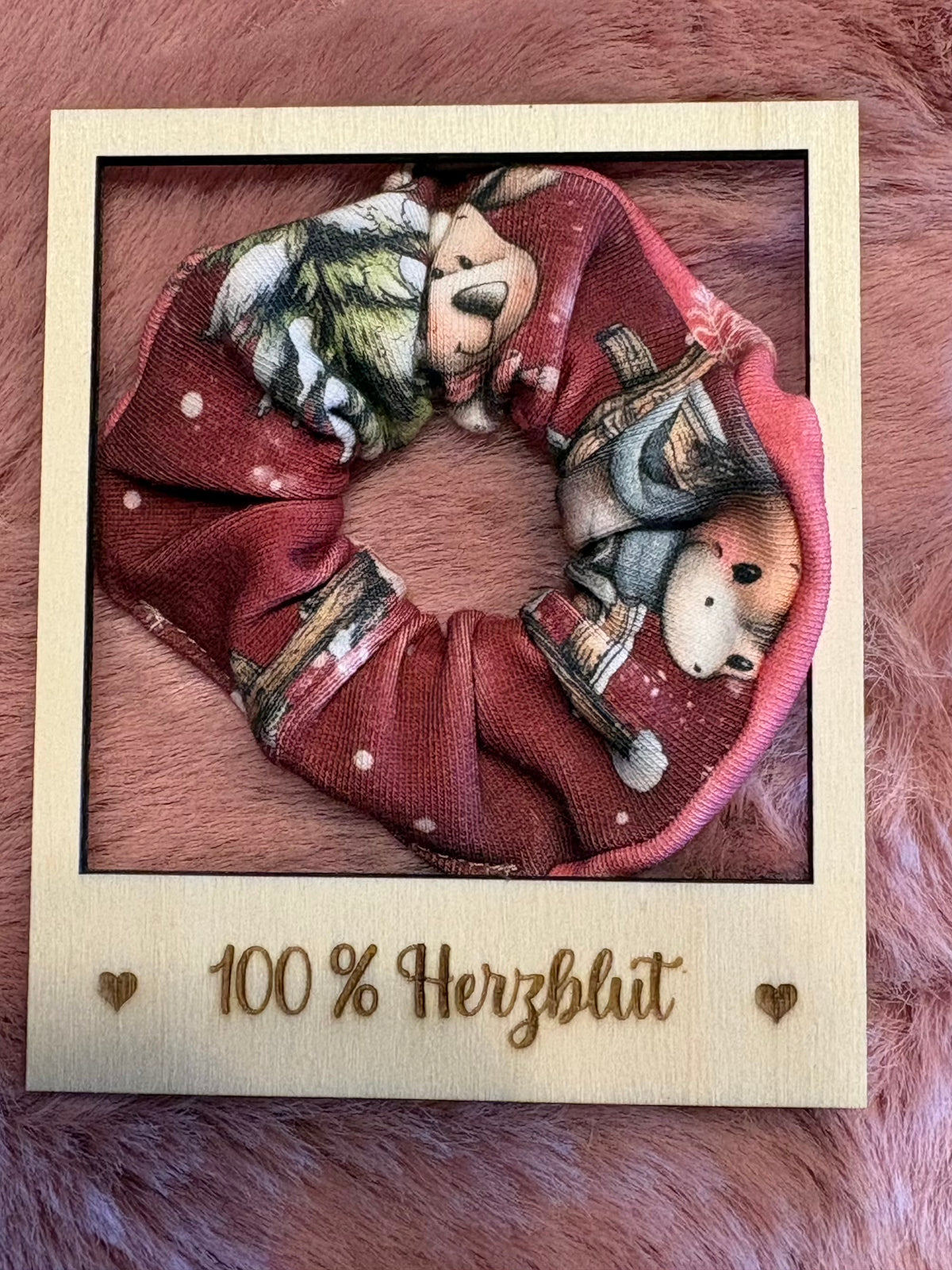 Detailaufnahme eines handgemachten Scrunchies aus bordeauxfarbenem Jersey mit Waldtier-Motiven
